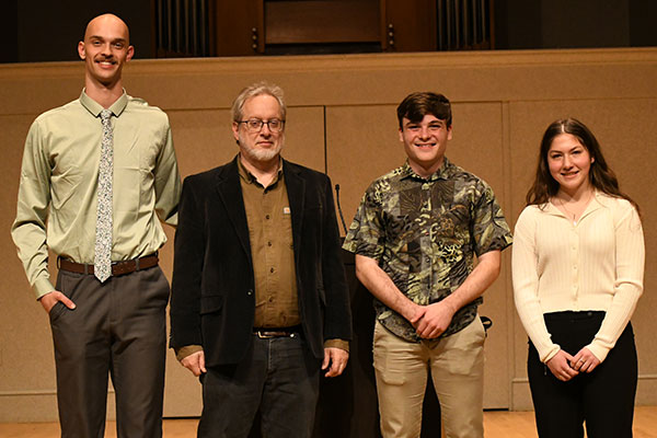 Winners of the 2025 peace oratorical contest pose with contest organizer Dr. Gerald Mast. Pictured are Coen North, second place; Micah Dodson, third place; and Mya Vernon, first place.
